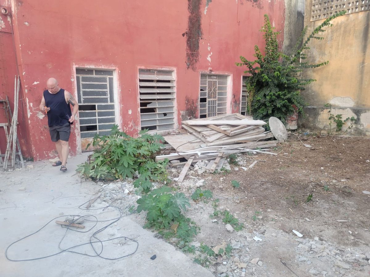 Ken Bell walking a debris-filled courtyard at one of his renovations in Mexico