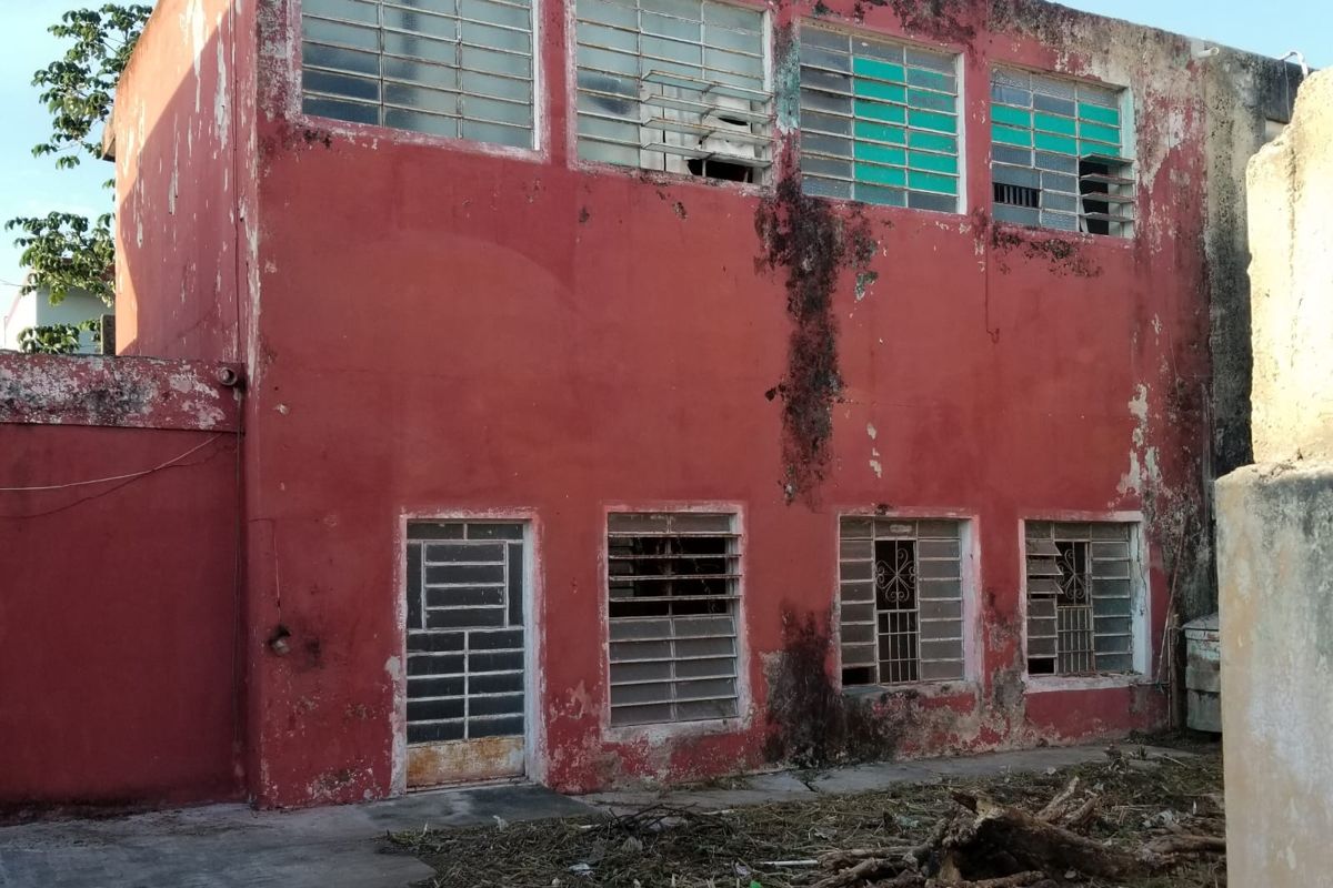 Weathered red facade of a house in Mexico before renovation
